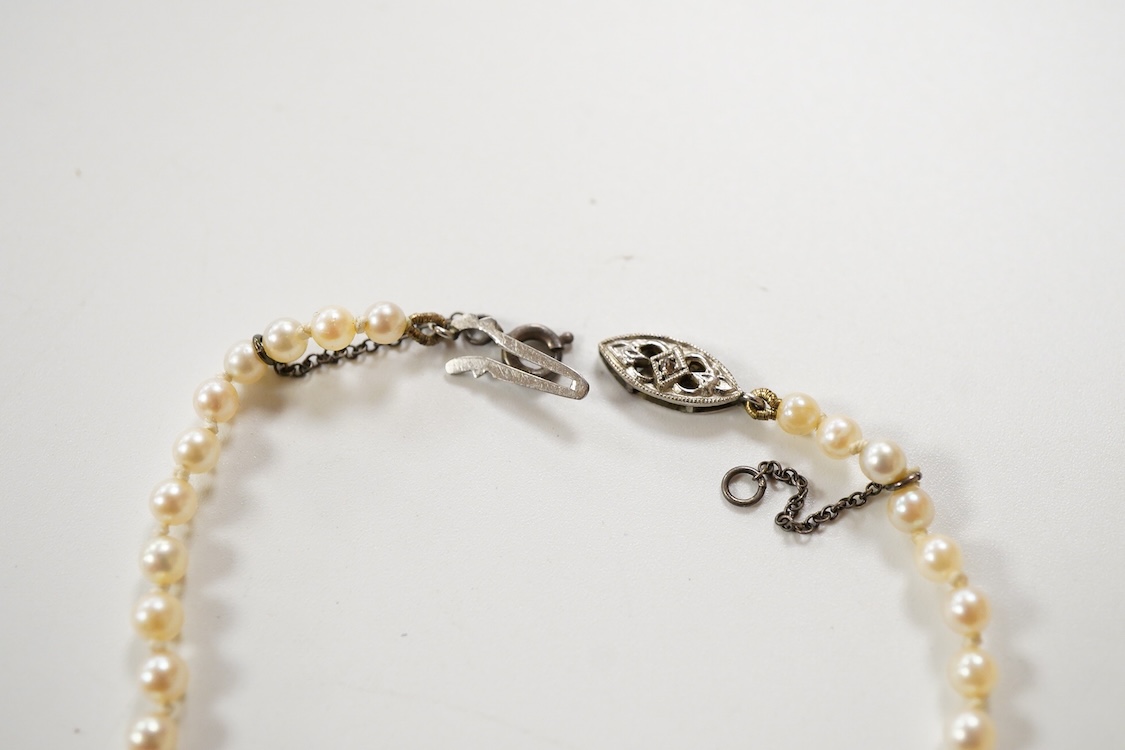 Two single strand graduated cultured pearl necklaces, one with a single stone rose cut diamond set 9ct white metal clasp, 42cm, together with a simulated pearl necklace and three assorted costume brooches.